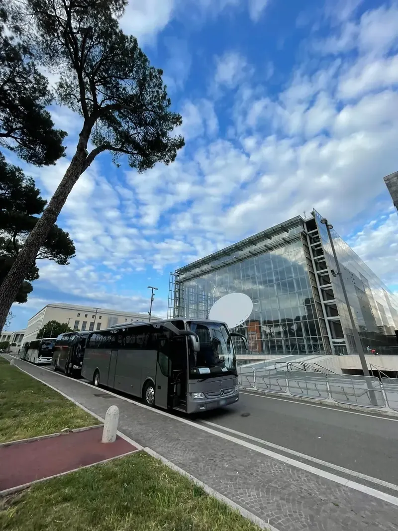 Pullman grigi in sosta lungo il viale davanti a La Nuvola, a Roma EUR