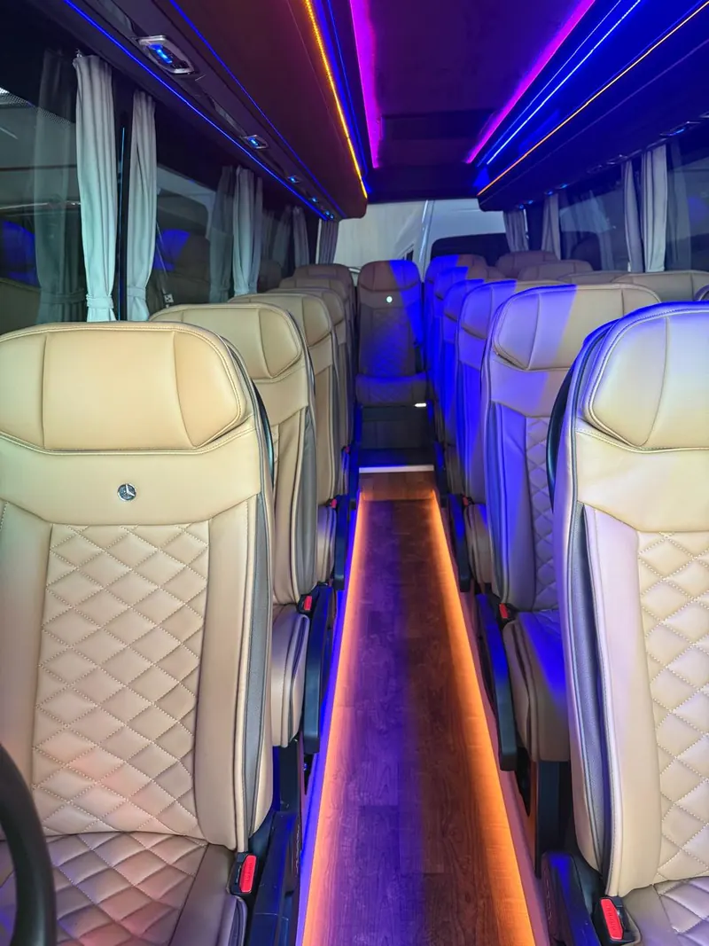Corsia centrale di un minibus con tendine ai finestrini e luci d'ambiente